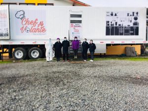 Grupo parado al lado de 2 caminiones