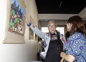 Mujer mostrando arpillera de la exposicion